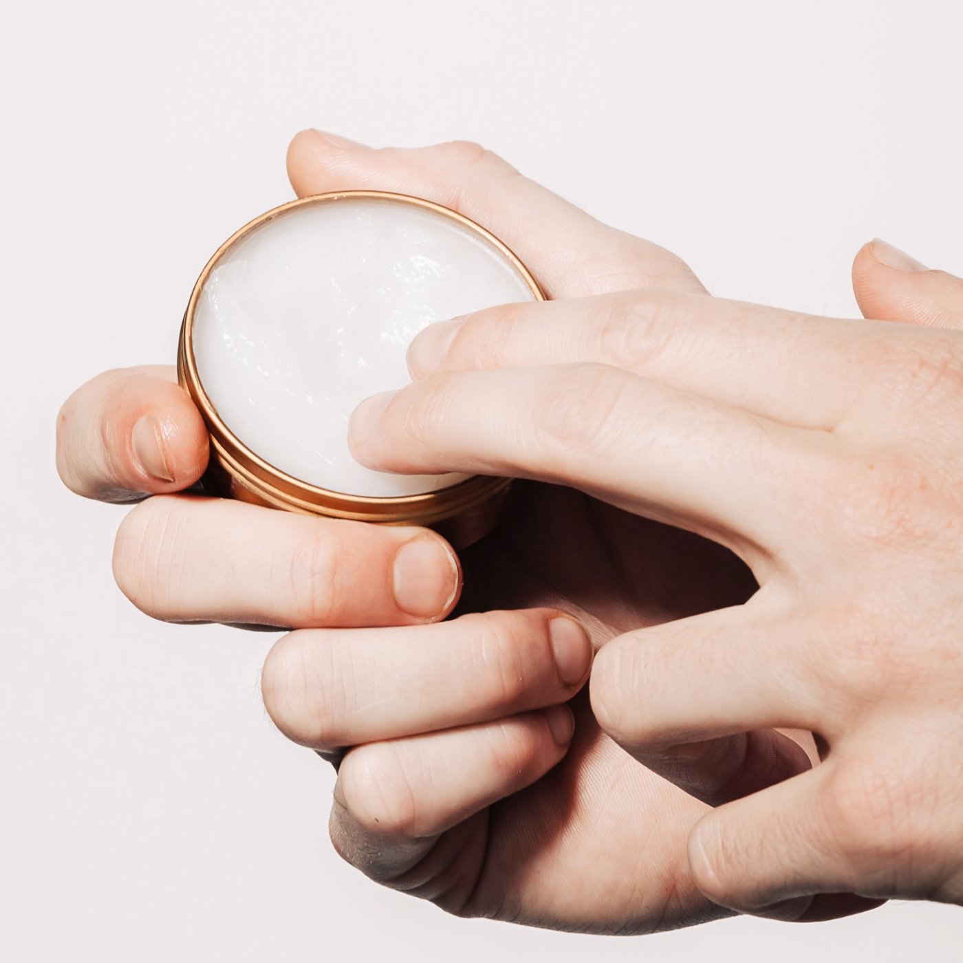 Caswell-Massey All-Purpose Healer. Image shows man's hands dipping into jar.